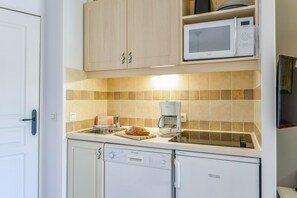 A compact kitchen with a microwave, coffee maker, and a loaf of bread on the counter. - Ardeche Holiday Apartment for 4 (Grospierres)