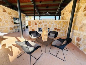An outdoor patio with stone walls, a wooden table, and four chairs.