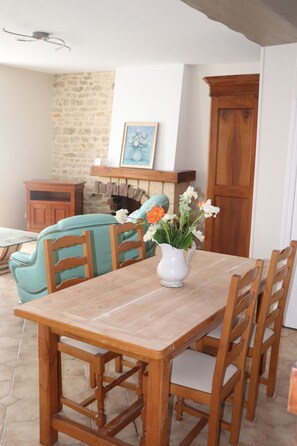 Ein Holzespeisesaal mit Stühlen, eine Blumenvase, eine Steinsäule und ein Holzschrank.