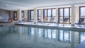 An indoor swimming pool with lounge chairs and large windows. - Mountainside Suite With Hot Tub (Araches-la-Frasse)