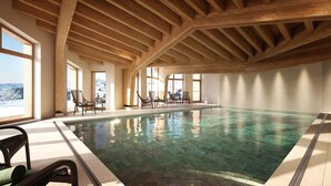 Ein Hallenbad mit Holzbalken, klarem Wasser und Stühlen.