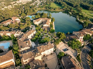 Vista aérea de una zona residencial con casas, un lago y un campo de golf.