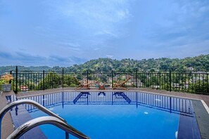 Una piscina en la azotea con vistas despejadas a un paisaje montañoso.