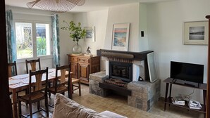 Un soggiorno con camino, zona pranzo e televisione.
