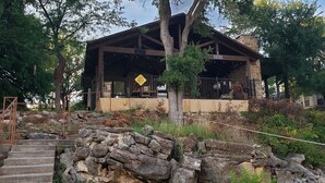 A rustic lodge with a stone facade, wooden beams, and a covered porch. - Lake Bridgeport Waterfront Charming Home with Private Dock / Boat & Jet Ski lift (Bridgeport)