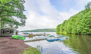 A lakeside dock with boats, a small building, and dense greenery. - Charming 2-bedroom condo with many activities to do around the area. (Lake Harmony)