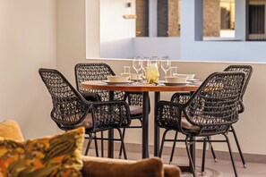 A dining area with a round table set for six, surrounded by black wicker chairs. - Curadise Penthouse - luxury poolside apartment in Jan Thiel (Jan Thiel)