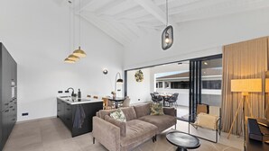 Un interior moderno con sofá, mesa de comedor y zona de cocina.