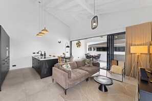 En modern inredning med en soffa, ett matbord och ett köksområde.