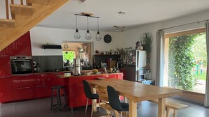 Uma cozinha moderna com armários vermelhos, uma mesa de jantar de madeira e uma janela grande.