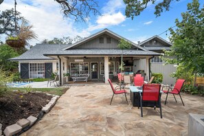 Ein Haus mit Terrasse, Sitzgelegenheit im Freien und einem Pool.