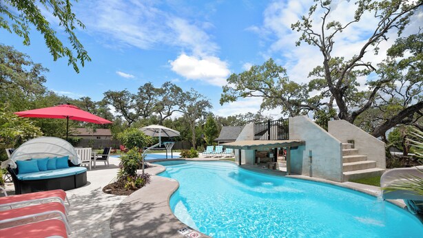 A swimming pool with lounge chairs and a covered seating area. - Luxury Pool, Hot Tub, Pickleball, Family Resort Getaway! (San Antonio)