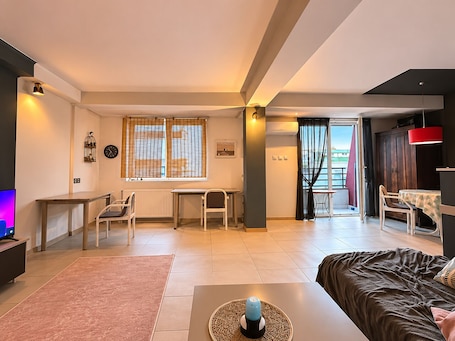 A modern apartment with a dining area, a workspace, and a bedroom.. Your Cozy Home in Skopje