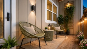 A wooden deck with wicker chairs, a small table, and potted plants. - Music City House, Sleeps 12 and Very close to Broadway, DT (Nashville)