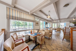 Un restaurante con terraza, suelo de piedra y vistas al exterior.