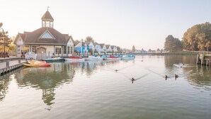 A waterfront building with a tower, docked fire boats, and calm water. - Coastal Retreat in Belle Dune (Fort-Mahon-Plage)