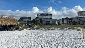 En strand med bygninger, heriblandt en bindingsværksbygning og moderne bygninger med store vinduer.