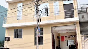 Um edifício de vários andares com uma placa indicando 'Shree Ram Shabd Home Stay' e 'Quarto com Ar Condicionado Disponível'.