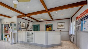 A reception desk with a sign for 'Pierre Vacances' and a map on the wall. - Picturesque Old Aquitaine Apartment for 5 (Biscarrosse)