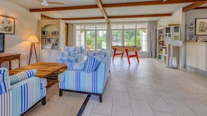 A spacious living area with striped sofas, a wooden coffee table, and a ceiling fan. - Picturesque Old Aquitaine Apartment for 5 (Biscarrosse)