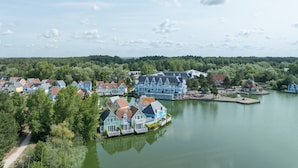 A lakeside village with houses along the water, a dock, and a path leading to the water. - House With Terrace Overlooking the Lake (Fort-Mahon-Plage)