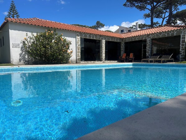 A clear swimming pool with a stone facade building in the background.