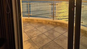 A balcony with a view of the ocean at sunset. - Sky Beachfront Escape, 180 degree ocean view, 15th floor (Cape Town)
