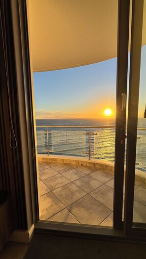 Ein Balkon mit Blick auf den Ozean im Sonnenuntergang.