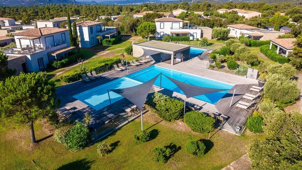 An aerial view of a residential area with a swimming pool, surrounded by houses and greenery. - Corsican Flat With Pergola (Lecci)