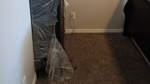 Une pièce dont le sol est recouvert d’une moquette, qui est équipée d’une prise électrique et qui contient un meuble recouvert de plastique.