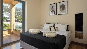 Una camera d'hotel moderna con un letto grande, vista sull'esterno e due opere d'arte astratte appese alla parete.