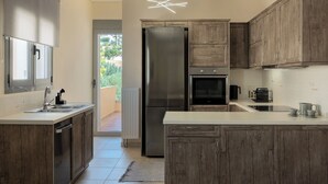 Una cucina moderna con mobili in legno, un frigorifero in acciaio inox e un originale lampadario.