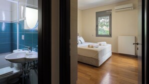 Una camera d'albergo con bagno, un letto, una finestra e un termosifone.