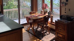 A dining area with a table, chairs, a lamp, and a view of the outdoors. - Spacious, sunlit, seaside 4-bedroom, 3 bath waterfront house w/ AC in Warren, RI (Warren)