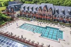 A hotel with a large swimming pool, multiple balconies, and a traditional European architectural style. - Houlgate Duplex for 8 With Spa (Houlgate)