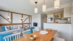 A modern kitchen with white brick walls, wooden beams, and pendant lighting. - Houlgate Duplex for 8 With Spa (Houlgate)