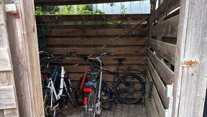 A wooden structure with a tiled floor, a bicycle rack, and a wooden fence. - Cozy bright 1 room apartment in Bramsche max. 3 persons (Bramsche)