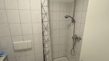 Un baño con inodoro, ducha y lavabo.