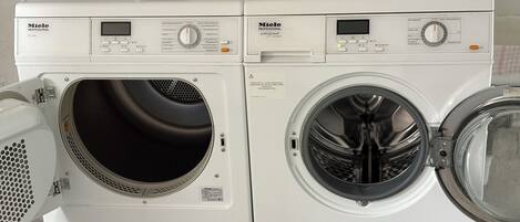 Two white Miele Professional PT 9136 washing machines side by side.