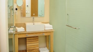Ein Badezimmer mit Waschbecken, Spiegel, Handtuchhalter und einer Tür.