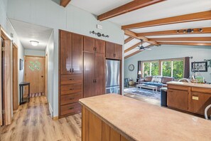 A spacious kitchen with wooden cabinets, a refrigerator, and a dining area with a sofa and table. - Waterfront Vacation with optional pontoon rental.  Relax in the great up north! (Pound)
