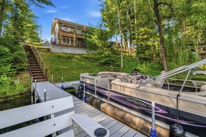 A boat docked at a pier with a modern building in the background. - Waterfront Vacation with optional pontoon rental.  Relax in the great up north! (Pound)