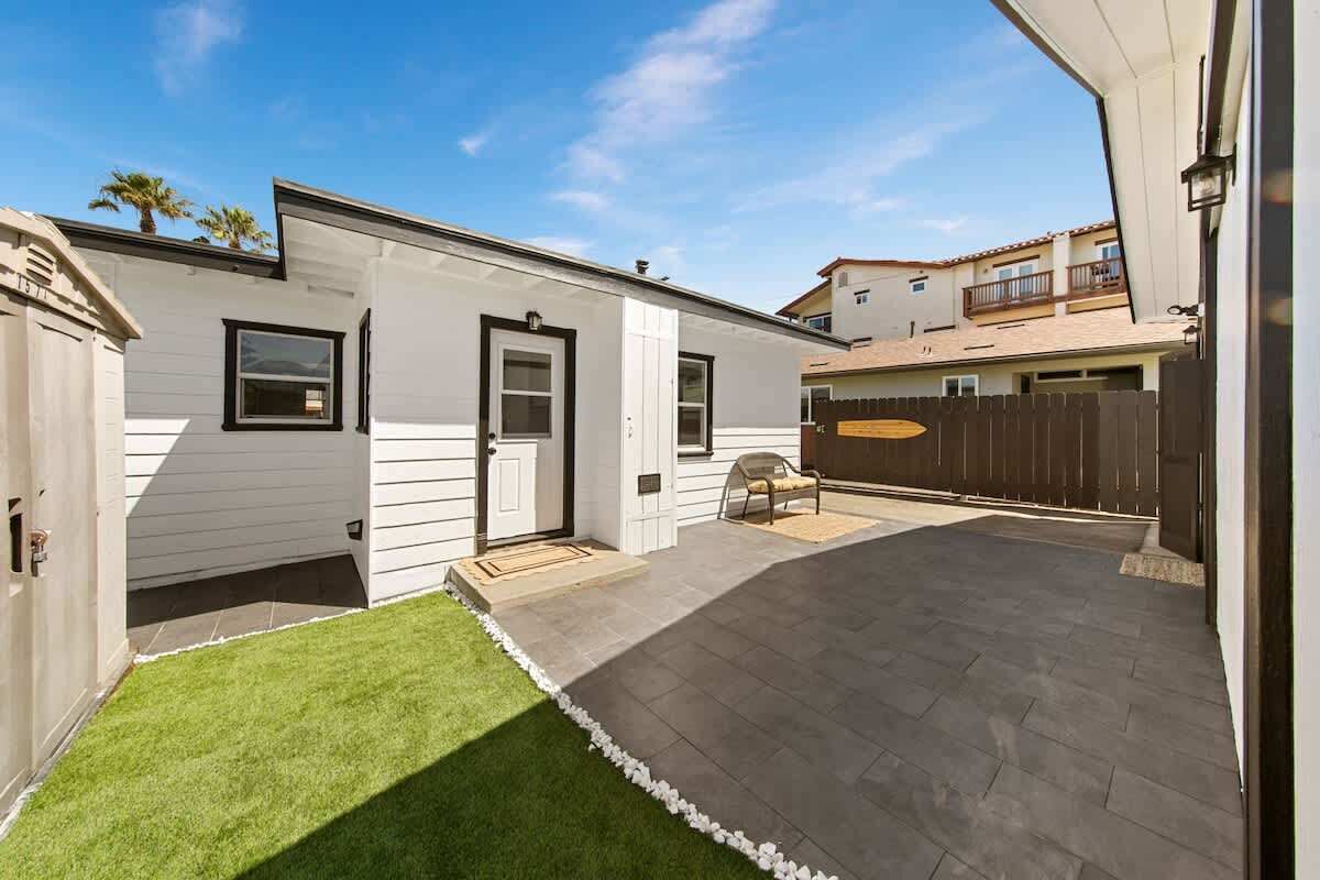 Il s’agit d’une propriété résidentielle dotée d’une terrasse dallée, d’une petite pelouse et d’une clôture en bois.