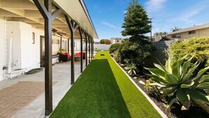 A covered outdoor area with artificial turf, a pathway, and a variety of plants. - 1 Bedroom Steps from Beach and Carlsbad Village (Carlsbad)