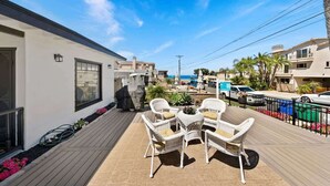 Un patio con mobiliario de mimbre, una piscina y vistas al mar.