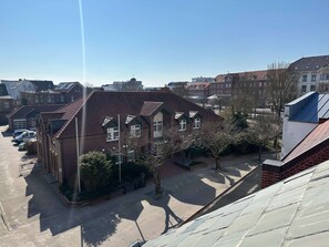 A residential building with a sloped roof, a garage, and a parking area. - Stylish ANTJE Apartment in STRAND HAUS 10 (Borkum)