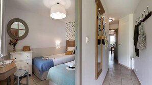 A bedroom with a bed, bedside table, dresser, and a mirror. - Premium Normandy Apartment for 4 (Houlgate)