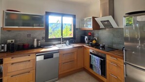 Una cucina moderna con mobili in legno, elettrodomestici in acciaio inossidabile e un'ampia finestra che offre luce naturale.