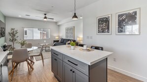 Una cucina moderna con isola centrale, zona pranzo e ventola a soffitto.