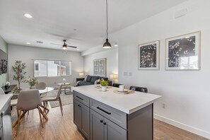 Eine moderne Küche mit einer zentralen Kochinsel, Essbereich und Deckenventilator.